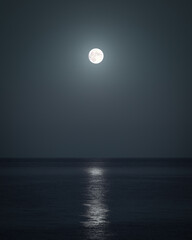 A dark moody sea with lonely glowing moon in Crimean peninsula at night