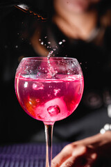 Splash of drink in a glass. Bartender preparing a cocktail