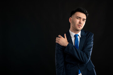 Portrait of business man wearing blue business suit and tie gesturing shoulder ache