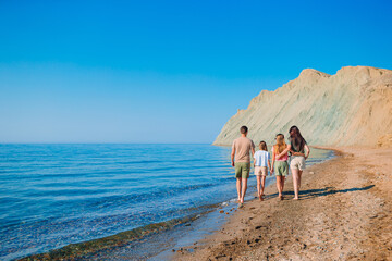 Happy beautiful family with kids on the beach