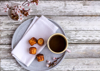 Top view of mug with coffe and some pastry on the old wooden table.
