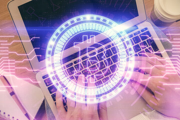 Double exposure of man's hands typing over computer keyboard and crypto currency theme hologram...