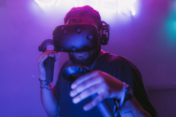 The guy is playing VR games. Neon blue light.