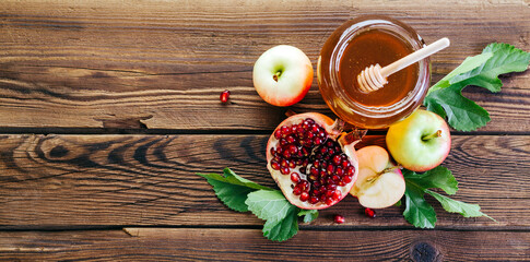 Rosh Hashanah. Jewish new year. Honey, pomegranate and apples on a wooden background.