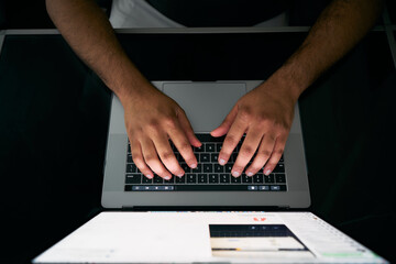 Fototapeta na wymiar Hands of ethnic man typing on keyboard