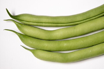 Four green beans freshly picked from the garden isolated on a white background