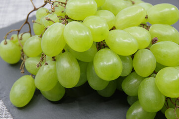 Green grapes on a gray background. Closeup