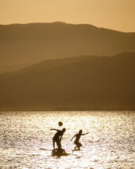 Fototapeta premium silhouette of kids playing in the sea during the sunset in Cabo de Gata, Almeria
