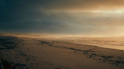 man walking on the beach at sunset