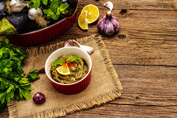 Eggplant dip baba ganoush (mutabbal) or mezze with ripe vegetables and fresh herbs