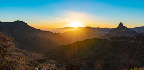 sunset between mountains with two famous rocks on the island of gran canaria el roque bentayga and...