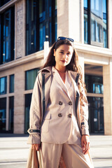 young pretty brunette woman in fashion suit at business building posing cheerful, lifestyle people concept