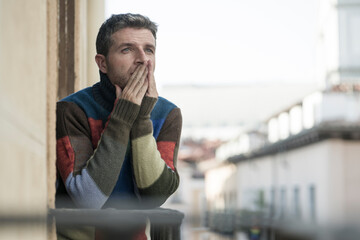 urban lifestyle emotional portrait of young attractive and depressed man at home balcony leaning upset feeling desperate suffering depression problem looking at city street