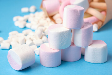 various shapes of marshmallows wrapped in paper on a blue background, close-up, eco friendly sweets...