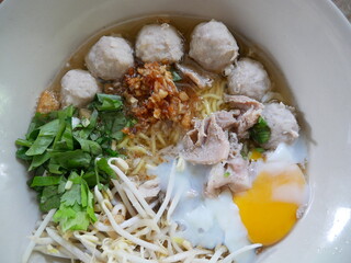Local thai noodle with soft boiled eggs, vegetable and meat ball in soup bowl  