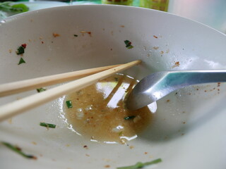 Empty soup bowl with spoon and chopsticks