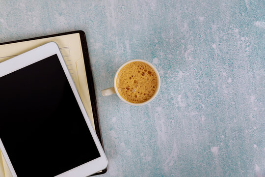 Workplace top view coffee cup and weekly planner for business with to do list on digital tablet