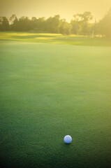 White Golf Ball on the Green Facing the Sunset