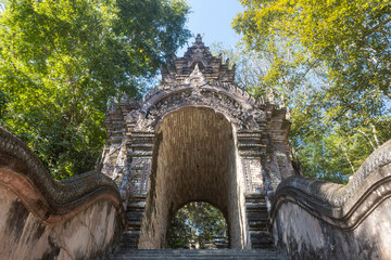 Naklejka premium Phayao, Thailand - Dec 8, 2019: Pagoda or Stupa Door of Wat Analayo or Analayo Temple on Blue Sky and Forest Background