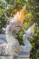 Phayao, Thailand - Dec 1, 2019: Two Serpent or Naga Statue on Green Tree Background in Analayo Temple at Phayao Thailand in Portrait View