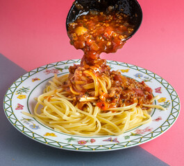 Delicious spaghetti with bolognese sauce served on a white square plate