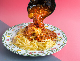 Delicious spaghetti with bolognese sauce served on a white square plate