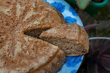 artisan breads on a wooden table dirty with flour and with ingredients olives, eggs and sausage and rosemary.
