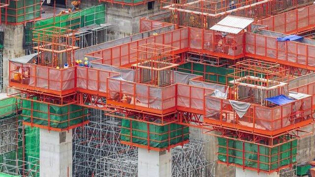 Footage 4k Timelapse, Overhead view of construction workers fabricating steel reinforcement bar on A suspended platform at the skyscraper construction site, The reinforcement bar was tied together.