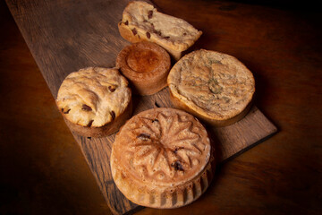 artisan breads on a wooden table dirty with flour and with ingredients olives, eggs and sausage and rosemary.