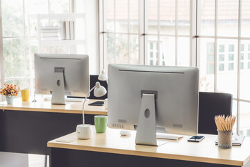 Desktop PC computers in small modern office or home office. Trendy workplace interior.