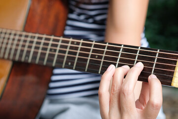 Obraz premium A young man playing string music ukulele in the summer