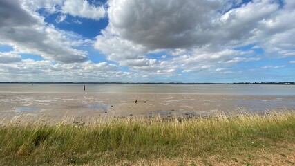 View of the broads National Park from the river bank in a cloudy day shoot taken against the sun with a dramatic sky and strong shadow in Great Yarmouth