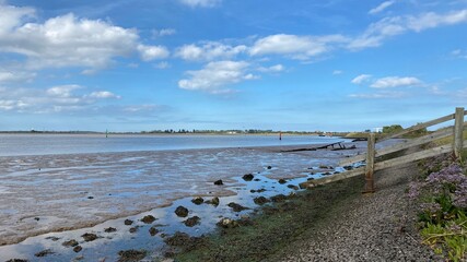 View of the broads National Park from the river bank in a cloudy day shoot taken against the sun with a dramatic sky and strong shadow in Great Yarmouth