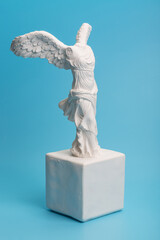 Greek goddess of victory sculpture on a blue background
