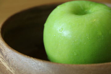 Closeup Green apple in wooden bowl