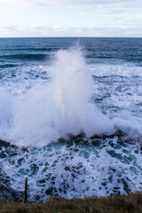Fototapeta na wymiar Wave crashing into the edge of rock pool.