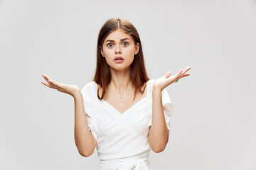 Emotional woman throws up her hands surprised look white dress cropped view 