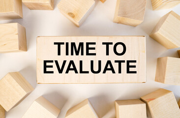 time to evaluate. text on wood board near wood cubes