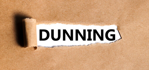 dunning. text is written on white paper on torn paper background