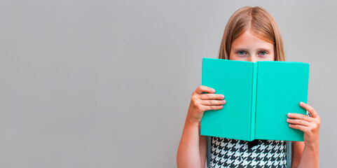 Close up portrait of close cover face behind diary. Girl ready to continue reading isolated on grey background