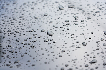 Water droplets on the surface of a modern glossy black car