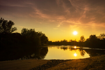 Obraz premium Wild, colorful sunset over tranquill river in a remote area in Europe