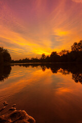 Obraz premium Wild, colorful sunset over tranquill river in a remote area in Europe