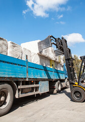 Forklift loading the bales of coton in a truck (TIR) - Cotton bales, ready for delivery to cotton buyers.