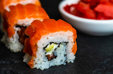 Sushi Set sashimi and sushi rolls served on stone slate