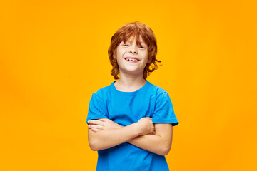 The red-haired happy child in a blue T-shirt 