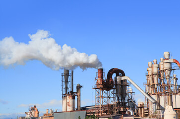 Industrial smoke from chimney on blue sky