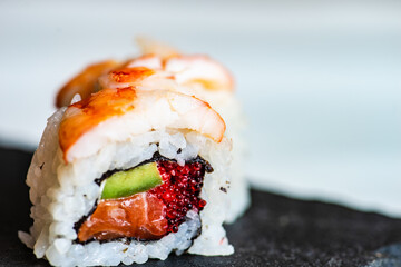 Sushi Set sashimi and sushi rolls served on stone slate