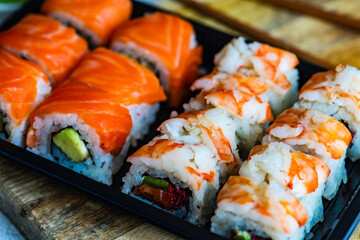 Sushi Set sashimi and sushi rolls served on stone slate