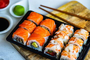 Sushi Set sashimi and sushi rolls served on stone slate